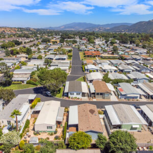 an aerial view showing the proximity of the home to the clubhouse and santa ynez mountains in the foreground